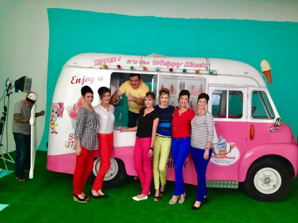 Models posing beside the classic pink and white ice cream van during a fashion catalogue shoot